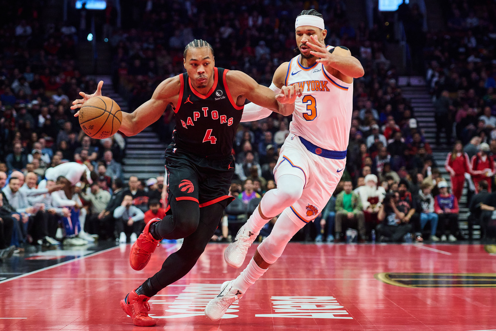 Toronto Raptors' Scottie Barnes (4) drives past New York Knicks' Josh Hart (3) during the first half of an NBA Cup basketball game in Toronto, Tuesday, Dec. 9, 2025. (Sammy Kogan/The Canadian Press via AP)