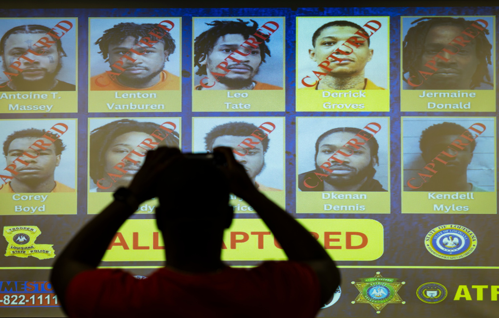 Media take photos of a display showing the captured inmates who broke out of prison months ago at Louisiana State Police offices in downtown New Orleans, Wednesday, Oct. 8, 2025. (Chris Granger/The Times-Picayune/The New Orleans Advocate via AP)