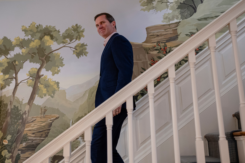 Kentucky Gov. Andy Beshear walks down the stairs before an interview, Monday, Jan. 12, 2026, in Frankfort, Ky. (AP Photo/Jon Cherry)