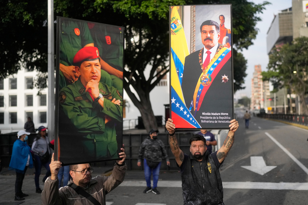 Government supporters display posters of Venezuelan President Nicolás Maduro, right, and former President Hugo Chávez in downtown Caracas, Venezuela, Saturday, Jan. 3, 2026, after U.S. President Donald Trump announced that Maduro had been captured and flown out of the country. (AP Photo/Matias Delacroix)