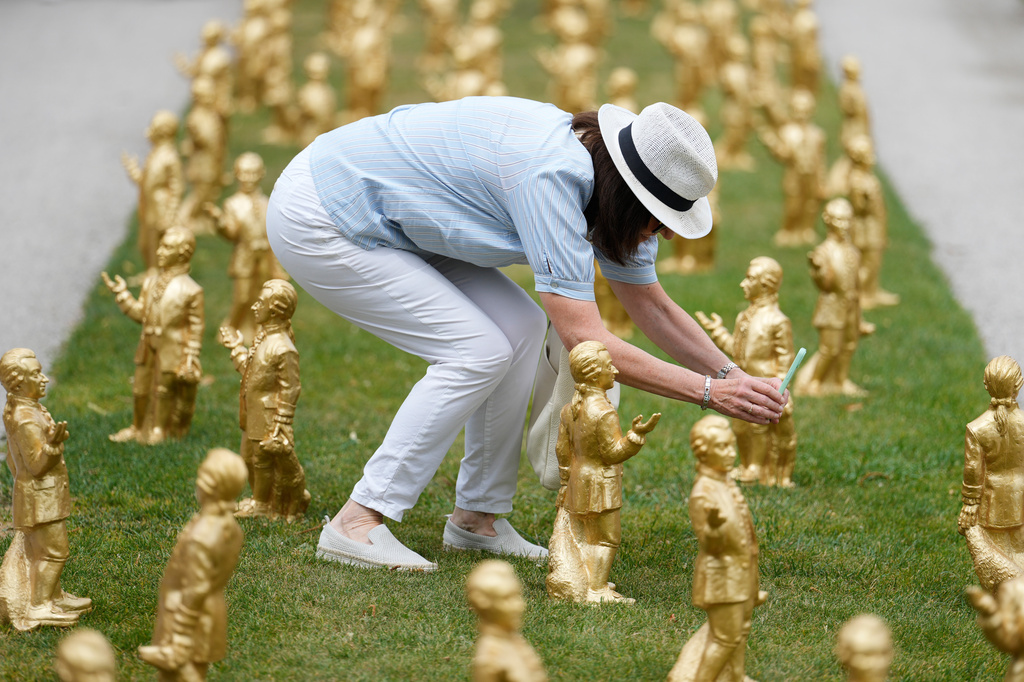 A woman takes pictures of 400 gold colored plastic Mozart sculptures by German artist Ottmar Hoerl from Nuremberg before the 270th birthday of composer Wolfgang Amadeus Mozart in Salzburg, Austria, Wednesday, July 15, 2026. (AP Photo/Matthias Schrader)