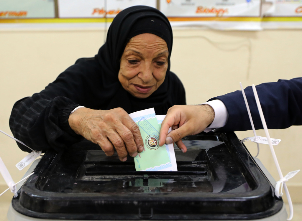 An Egyptian woman casts her ballot during the second phase of parliamentary elections in Cairo, Egypt, Monday, Nov. 24, 2025. (AP Photo/Khaled Elfiqi)