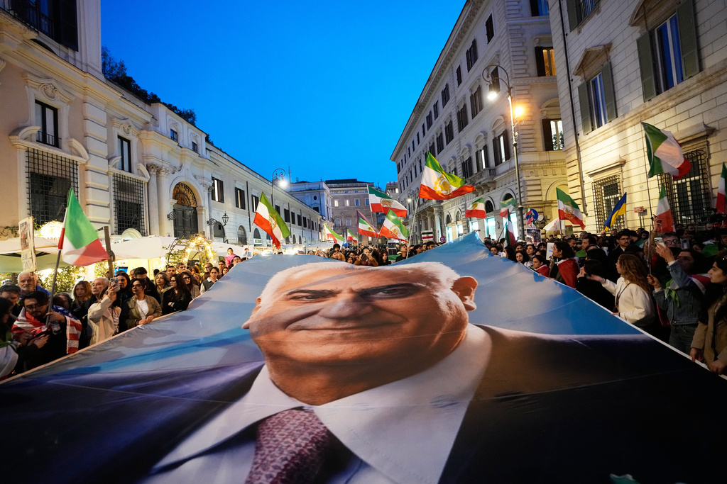 Demonstrators display a banner with Iran's exiled Crown Prince Reza Pahlavi as they gather in Rome, Tuesday, March 3, 2026. (AP Photo/Alessandra Tarantino)