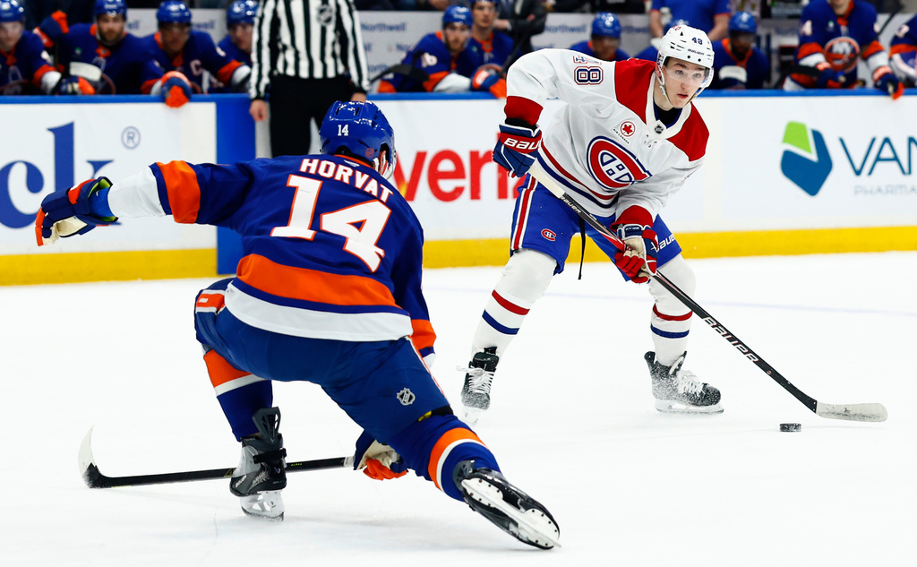 Montréal Canadiens defenseman Lane Hutson (48) plays the puck against New York Islanders center Bo Horvat (14) during the first period of an NHL hockey game, Sunday, April 12, 2026, in New York. (AP Photo/Noah K. Murray) CORRECTION: Corrects to Elmont, N.Y., not New York.
