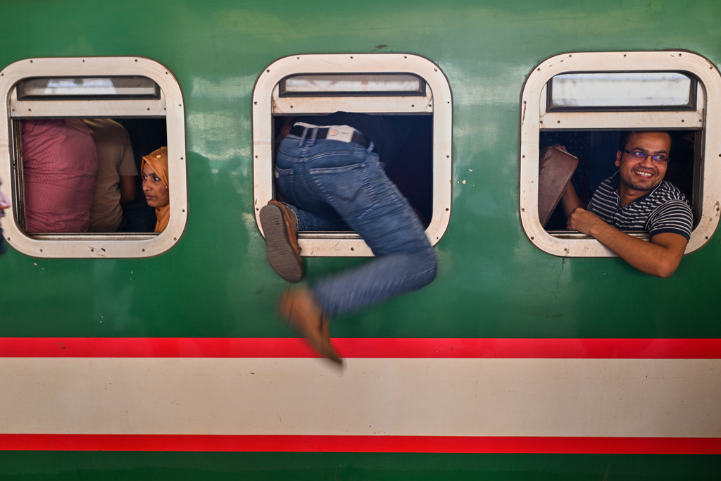 Homebound travelers scramble to board a train at Kamalapur Railway Station, joining the massive annual exodus to celebrate Eid al-Fitr, in Dhaka, Bangladesh, Wednesday, March 18, 2026. (AP Photo/Mahmud Hossain Opu)