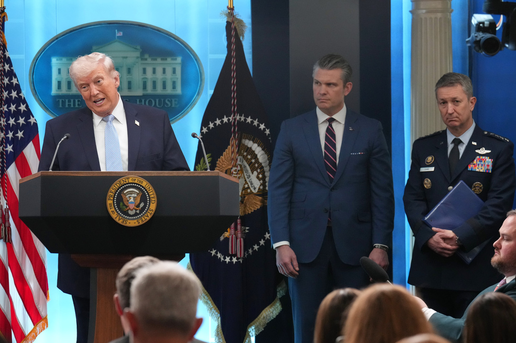 President Donald Trump speaks with reporters during a news conference in the James Brady Press Briefing Room at the White House, Monday, April 6, 2026, in Washington, as Defense Secretary Pete Hegseth and Chairman of the Joint Chiefs of Staff Gen. Dan Caine listen. (AP Photo/Mark Schiefelbein)