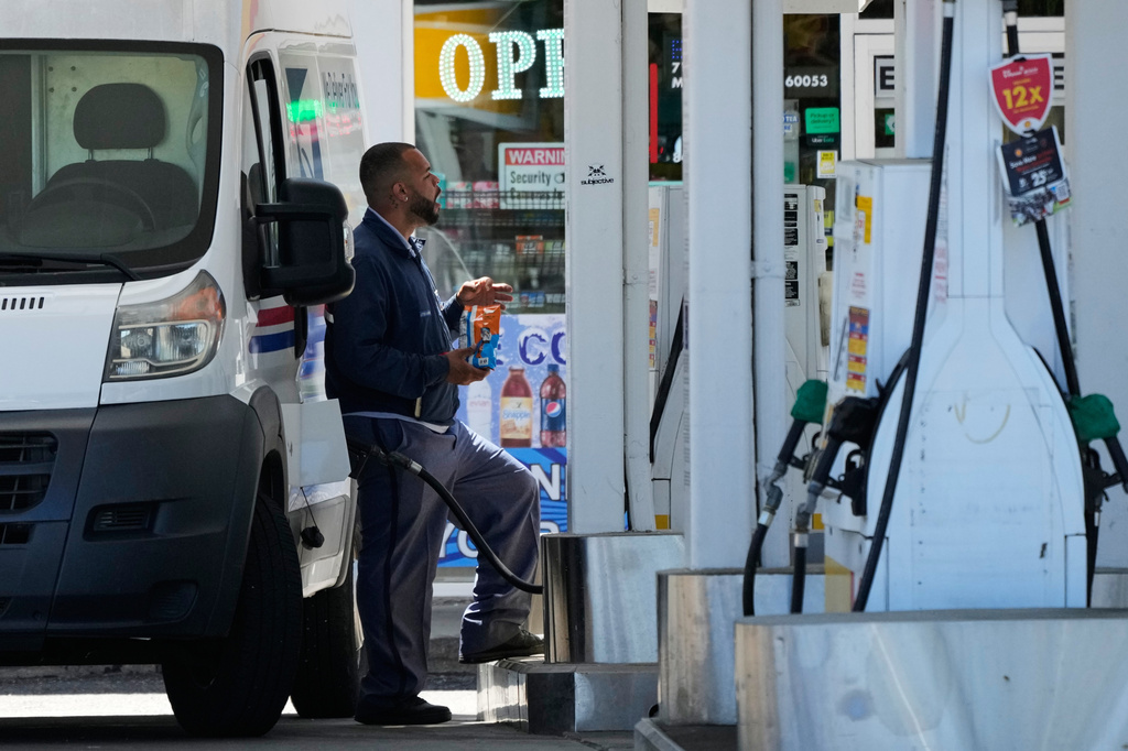 A man fills up his vehicle's gas tank at a gas station in Morton Grove, Ill, Thursday, May 14, 2026. (AP Photo/Nam Y. Huh)