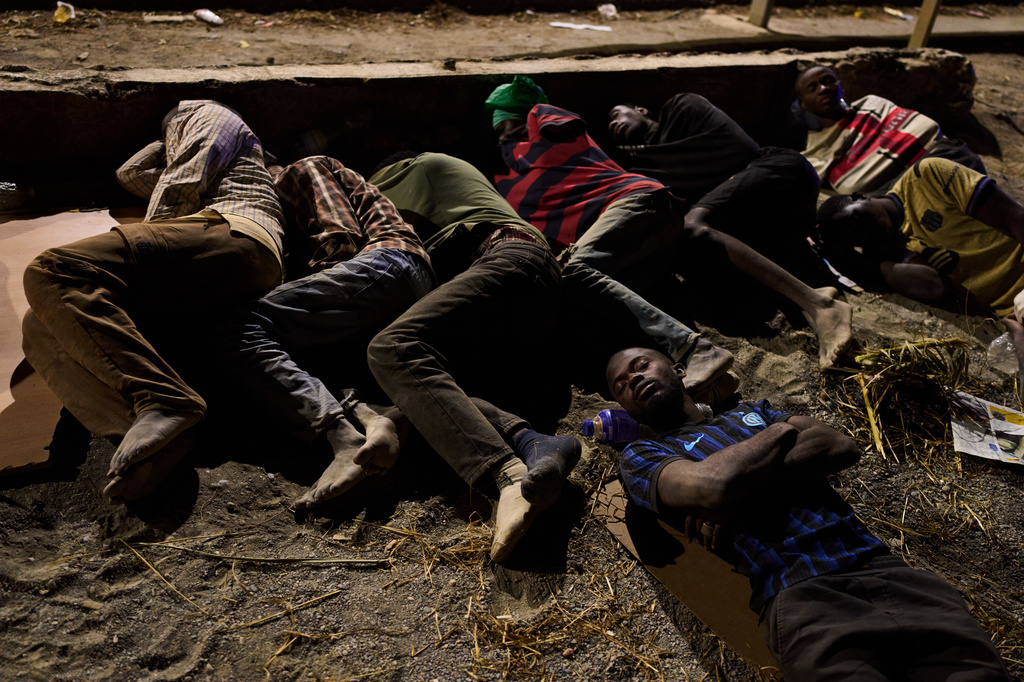 Migrants who crossed into Spain from Morocco sleep on a beach in the Spanish enclave of Ceuta, Monday, Aug. 3, 2026. (AP Photo/Bernat Armangue)