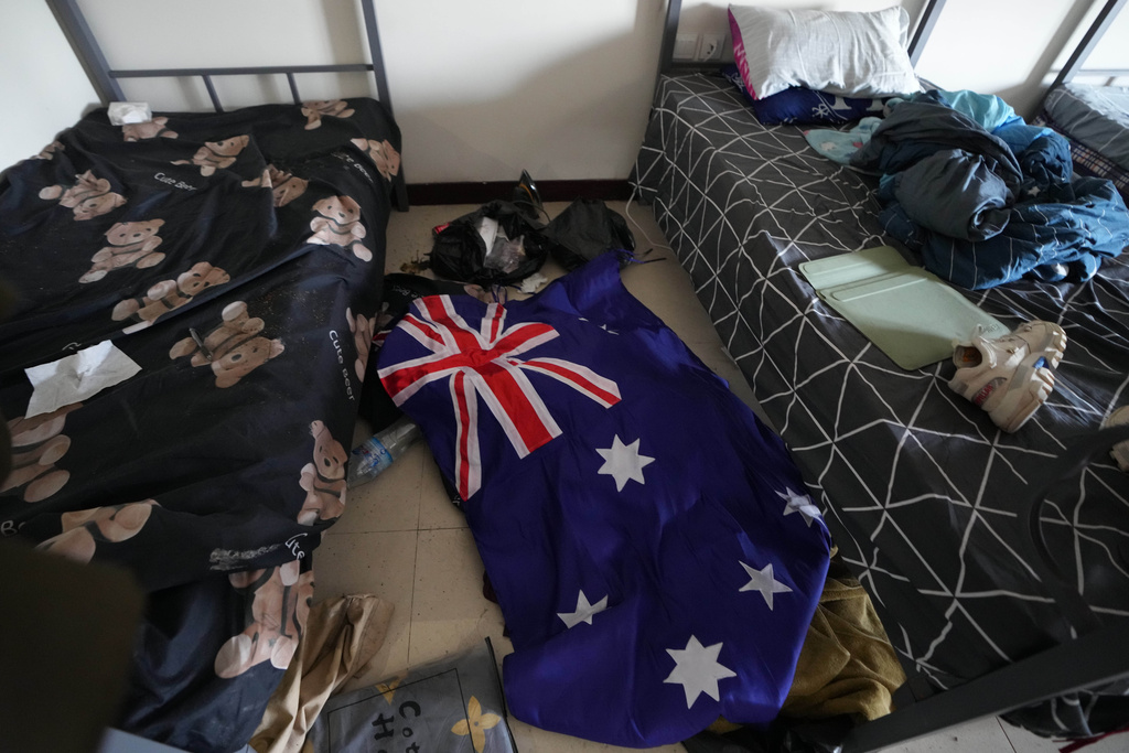 An Australian flag lies on the floor of an abandoned bedroom at a scam center in O'Smach, Cambodia, Monday, Feb. 2, 2026. (AP Photo/Sakchai Lalit)