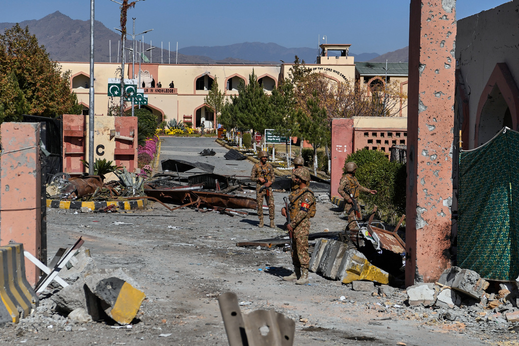 Army soldiers stand guard next to a damaged area at the main gate of an army-run cadet college that was assaulted by militants on Monday, in Wana, a city in the northwestern Pakistani district South Waziristan bordering with Afghanistan, Thursday, Nov. 13, 2025. (AP Photo/Ahsan Shahzad)