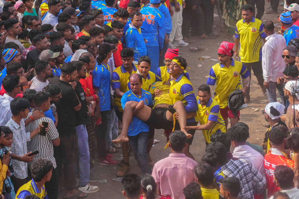 Volunteers carry an injured participant who was hurt while competing in the erection of ceremonial bamboo poles, during a centuries-old annual tradition honoring goddess Raiba Devi in Rave village, near Mumbai, India, Friday, April 17, 2026. (AP Photo/Rafiq Maqbool)