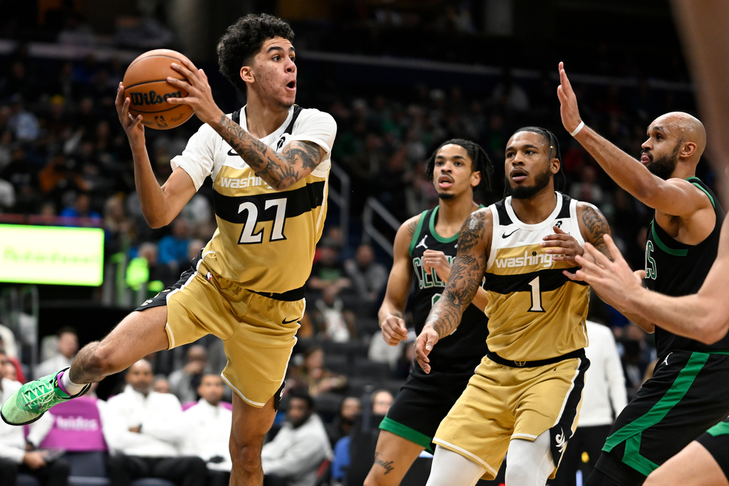 Washington Wizards guard Will Riley (27) looks to pass off under the basket during the first half of an NBA basketball game against the Boston Celtics Thursday, Dec. 4, 2025, in Washington. (AP Photo/John McDonnell)