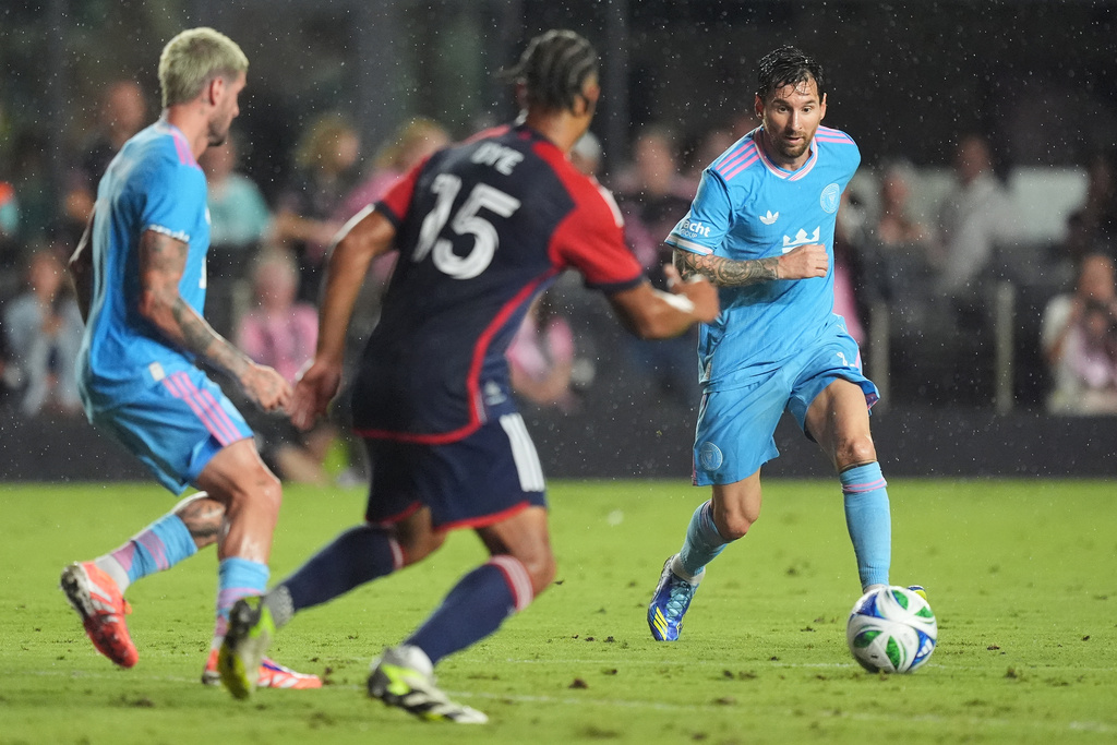 Inter Miami forward Lionel Messi, right, controls the ball as New England Revolution midfielder Brandon Bye (15) and Inter Miami midfielder Rodrigo de Paul look on during the first half of an MLS soccer match, Saturday, Oct. 4, 2025, in Fort Lauderdale, Fla. (AP Photo/Rebecca Blackwell)