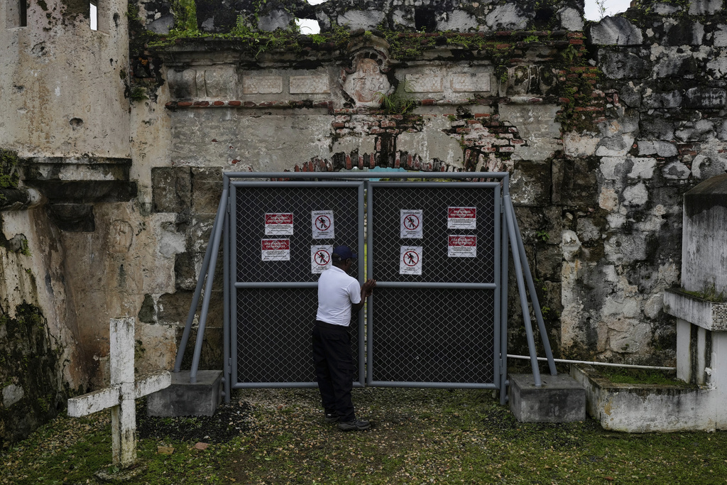 A security guard closes a gate of Fort San Jeronimo, a 17th-century Spanish fort that defended the Caribbean port of Portobelo, where treasure fleets loaded silver and gold for shipment to Europe, in Panama, Thursday, Aug. 14, 2025. (AP Photo/Matias Delacroix)