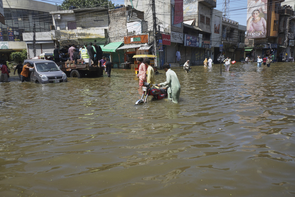 Residents navigate through a flooded road following by heavy rains, in Gujrat, Pakistan, Thursday, Sept. 4, 2025. (AP Photo/A. Rizvi)