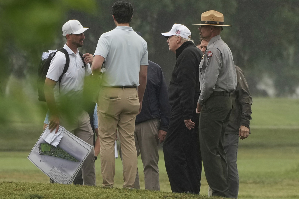 President Donald Trump, second right, tours the East Potomac Park golf course alongside a person carrying blueprints, Sunday, June 28, 2026, in Washington. (AP Photo/Mark Schiefelbein)