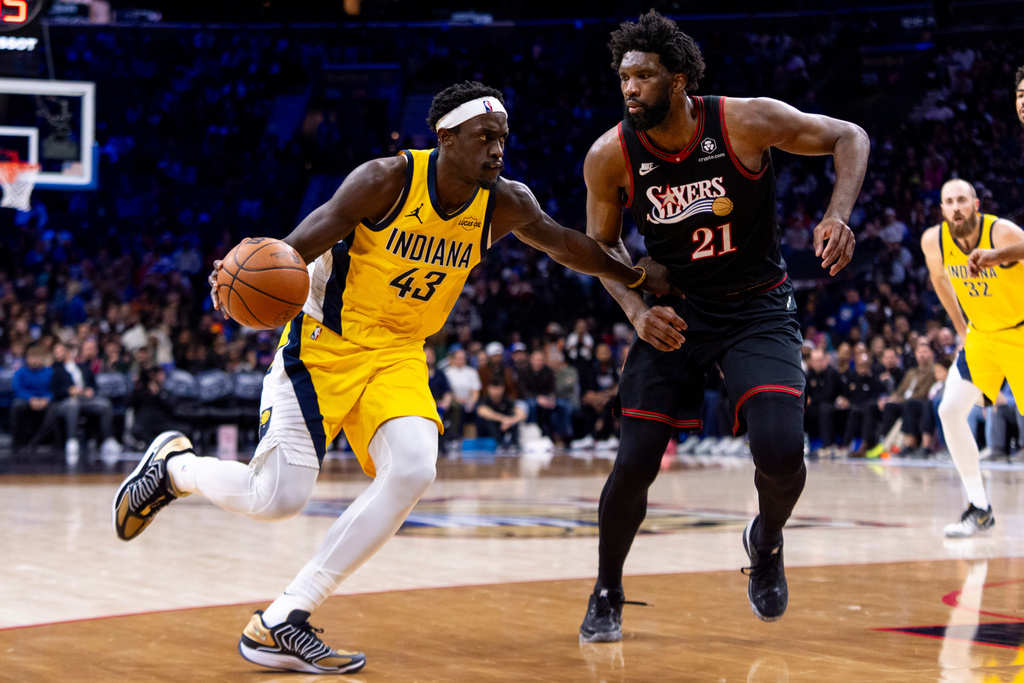 Indiana Pacers' Pascal Siakam, left, drives to the basket against Philadelphia 76ers' Joel Embiid, right, during the second half of an NBA basketball game, Friday, Dec. 12, 2025, in Philadelphia. (AP Photo/Chris Szagola)