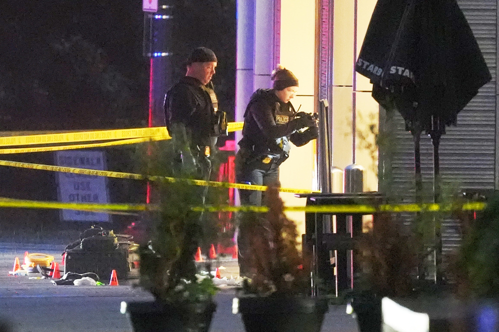 U.S. Secret Service Police examine and photograph evidence at a crime scene near the White House, Saturday, May 23, 2026, in Washington. The U.S. Secret Service shot a person near the White House on Saturday, and a bystander also was shot, a law enforcement official said. (AP Photo/Alex Brandon)