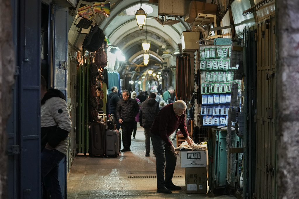 A man displays his goods for sale in front of his shop at a market, after restrictions were lifted following a ceasefire reached between Iran, Israel and the United States, in the Old City of Jerusalem, Thursday, April 9, 2026. (AP Photo/Mahmoud Illean)