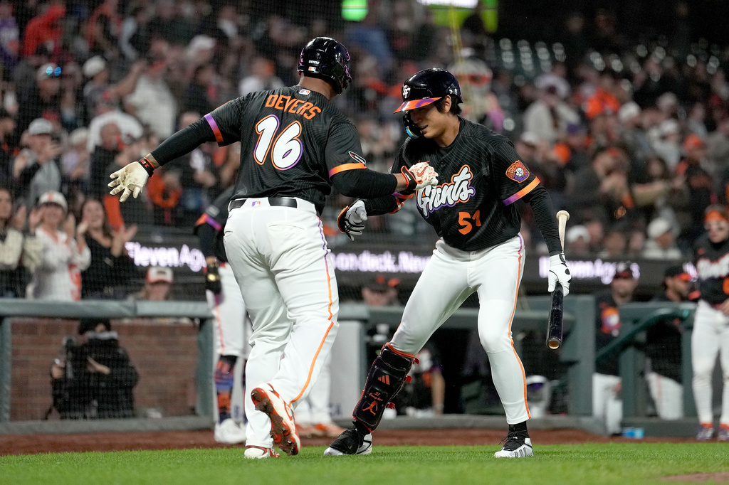 San Francisco Giants' Rafael Devers (16) is congratulated by teammate Jung Hoo Lee (51) after hitting a home run against the Cincinnati Reds during the fifth inning of a baseball game Tuesday, Aug. 25, 2026, in San Francisco. (AP Photo/Tony Avelar)