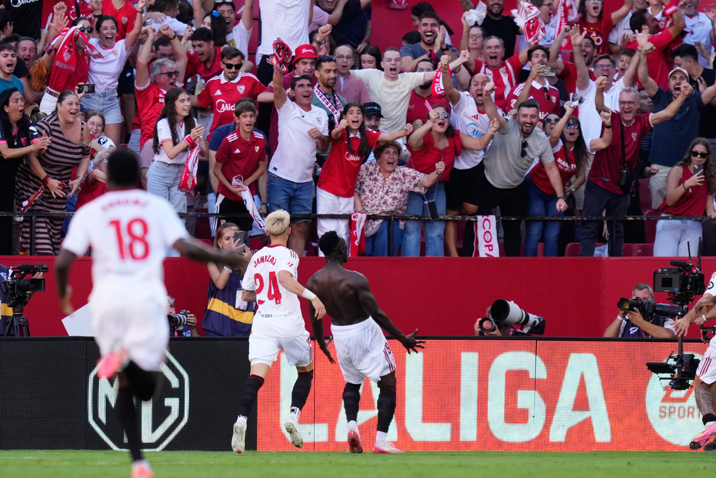 Sevilla's Akor Adams, centre, celebrates after scoring his side's fourth goal during the Spanish La Liga soccer match between Sevilla and Barcelona at the Ramon Sanchez Pizjuan stadium in Seville, Spain, Sunday, Oct. 5, 2025. (AP Photo/Jose Breton)