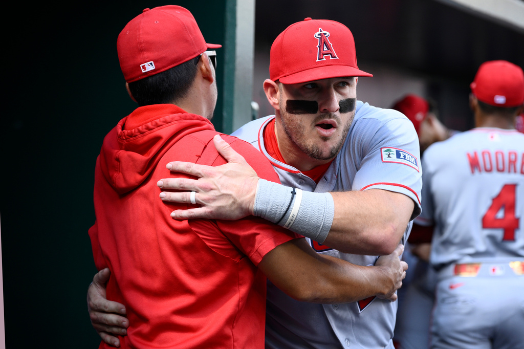 Los Angeles Angels' Mike Trout, right, and manager Kurt Suzuki, left, hug before a baseball game against the Washington Nationals, Sunday, Sept. 13, 2026, in Washington. (AP Photo/Nick Wass)