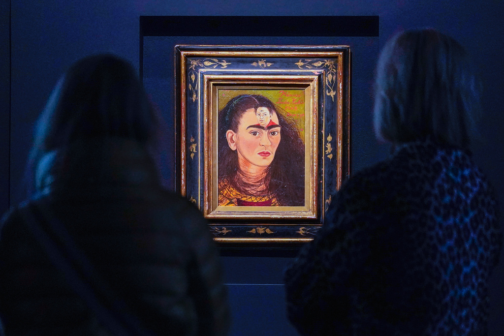 FILE - Visitors look a Frida Kahlo painting titled, "Diego y yo" or Diego and I, on display at Sotheby's auction house during a press preview in New York, Nov. 5, 2021. (AP Photo/Mary Altaffer, File)