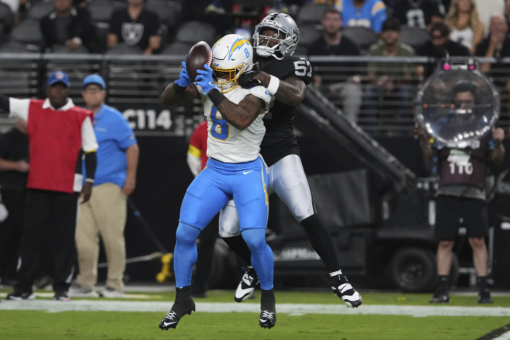 Los Angeles Chargers running back Omarion Hampton (8) misses a catch attempt against Las Vegas Raiders linebacker Germaine Pratt (57) during the first half of an NFL football game, Monday, Sept. 15, 2025, in Las Vegas. (AP Photo/Rick Scuteri)