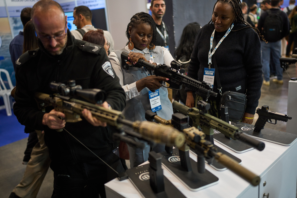 Visitors examine weapons on display at a defense industry exhibition in Tel Aviv, Israel, Tuesday, Feb. 17, 2026. (AP Photo/Oded Balilty)
