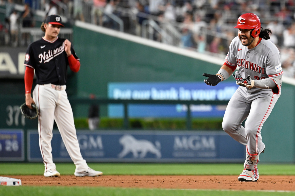 Cincinnati Reds' Eugenio Suárez, right, celebrates after his solo home run as he runs by Washington Nationals third baseman Brady House during the second inning of a baseball game, Friday, Aug. 7, 2026, in Washington. (AP Photo/John McDonnell)
