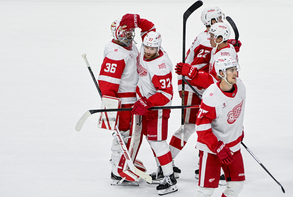 Detroit Red Wings' J.T. Compher (37) celebrates with his teammates and goaltender John Gibson (36) following their win in overtime NHL hockey game over the Ottawa Senators, in Ottawa, Ontario, Thursday, Feb. 26, 2026. (Spencer Colby/The Canadian Press via AP)