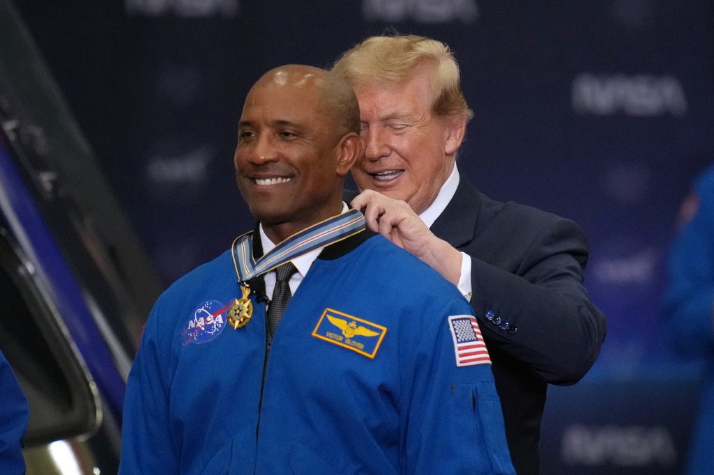 President Donald Trump participates in a Congressional Space Medal of Honor ceremony at NASA's Johnson Space Center, Friday, Aug. 28, 2026, in Houston, and puts a medal on Artemis II Astronaut and Pilot Victor Glover. (AP Photo/Karen Warren)