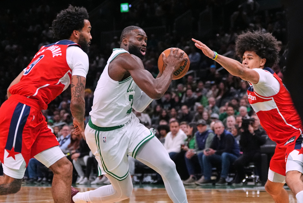 Boston Celtics forward Jaylen Brown, center, drives to the basket between Washington Wizards forward Justin Champagnie (9) and forward Kyshawn George, right, during the first half of an NBA basketball game, Wednesday, Nov. 5, 2025, in Boston. (AP Photo/Charles Krupa)