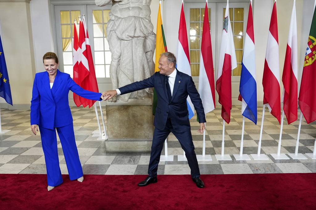 Denmark's Prime Minister Mette Frederiksen, left, shares a light moment with Poland's Prime Minister Donald Tusk as she welcomes him for an informal summit in the Danish parliament at Christiansborg Castle in Copenhagen, Wednesday, Oct. 1, 2025. (Liselotte Sabroe/Ritzau Scanpix via AP)