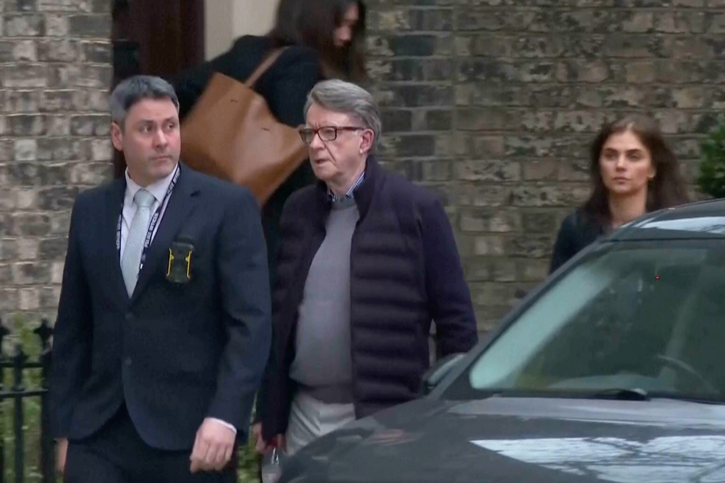 This image taken from video made available by Sky News shows Peter Mandelson, center, escorted from a house to a car, in London, Monday Feb. 23, 2026. (Sky News via AP)