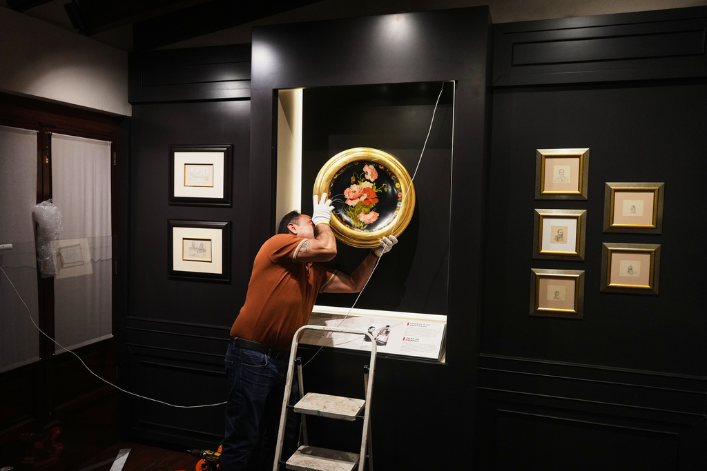 A curator hangs “A Tray of Poppies”, one of Frida Kahlo’s first works that she painted as gift for her Aunt Ana, in preparation for the opening of the new museum Casa Kahlo, a house bought by Kahlo’s father after he gave the iconic Casa Azul to his daughter as a wedding gift, in Mexico City, Wednesday, Sept. 10, 2025. (AP Photo/Eduardo Verdugo)