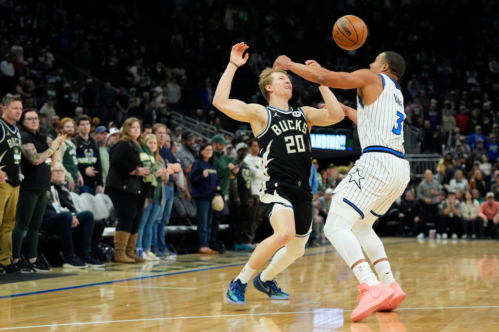 Milwaukee Bucks' AJ Green (20) loses control of the ball against Orlando Magic's Desmond Bane during the first half of an NBA basketball game Sunday, March 8, 2026, in Milwaukee. (AP Photo/Aaron Gash)