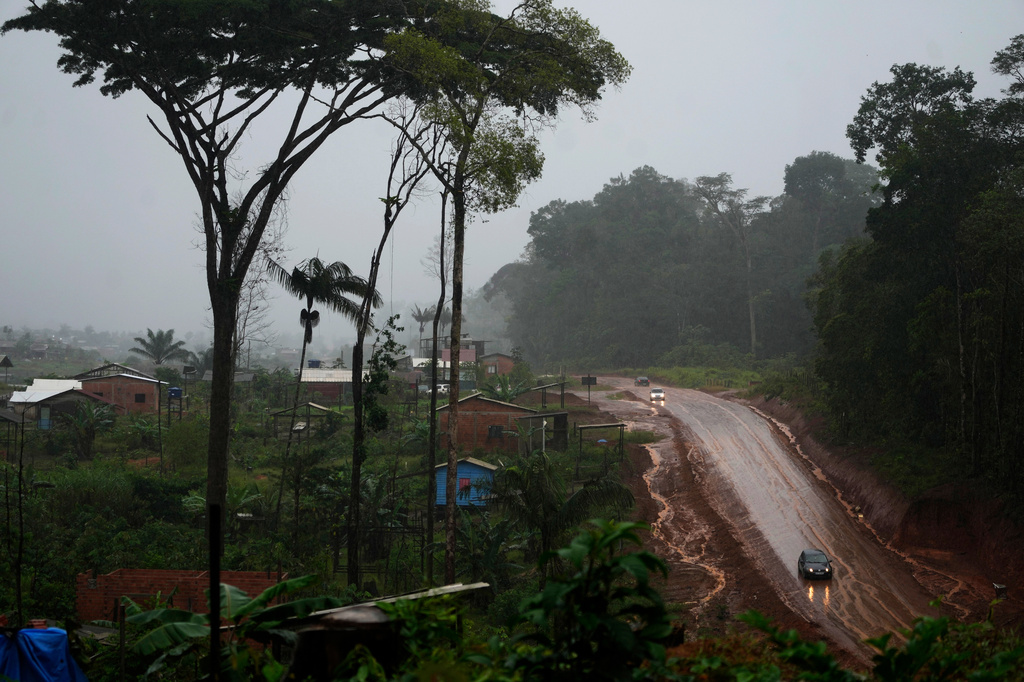 Vehicles move down a road in area known as Nova Conquista or New Conquest where families are building houses near the center of Oiapoque, Amapa state, Brazil, Wednesday, March 11, 2026. (AP Photo/Eraldo Peres)