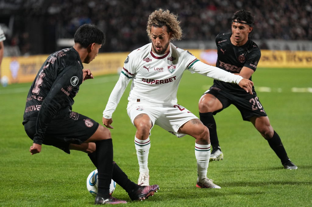 Guga of Brazil's Fluminense, center, and Alvaro Lagos of Argentina's Platense battle for the ball during a Copa Libertadores quarter final second leg soccer match in Buenos Aires, Argentina, Tuesday, Sept. 15, 2026. (AP Photo/Gustavo Garello)