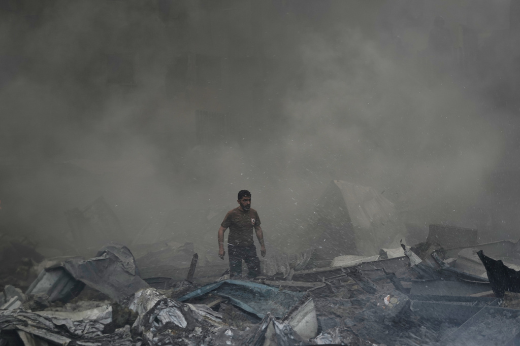 A first responder emerges through the smoke at the site of an Israeli airstrike that struck an apartment building in Beirut, Lebanon, Wednesday, April 8, 2026. (AP Photo/Bilal Hussein)