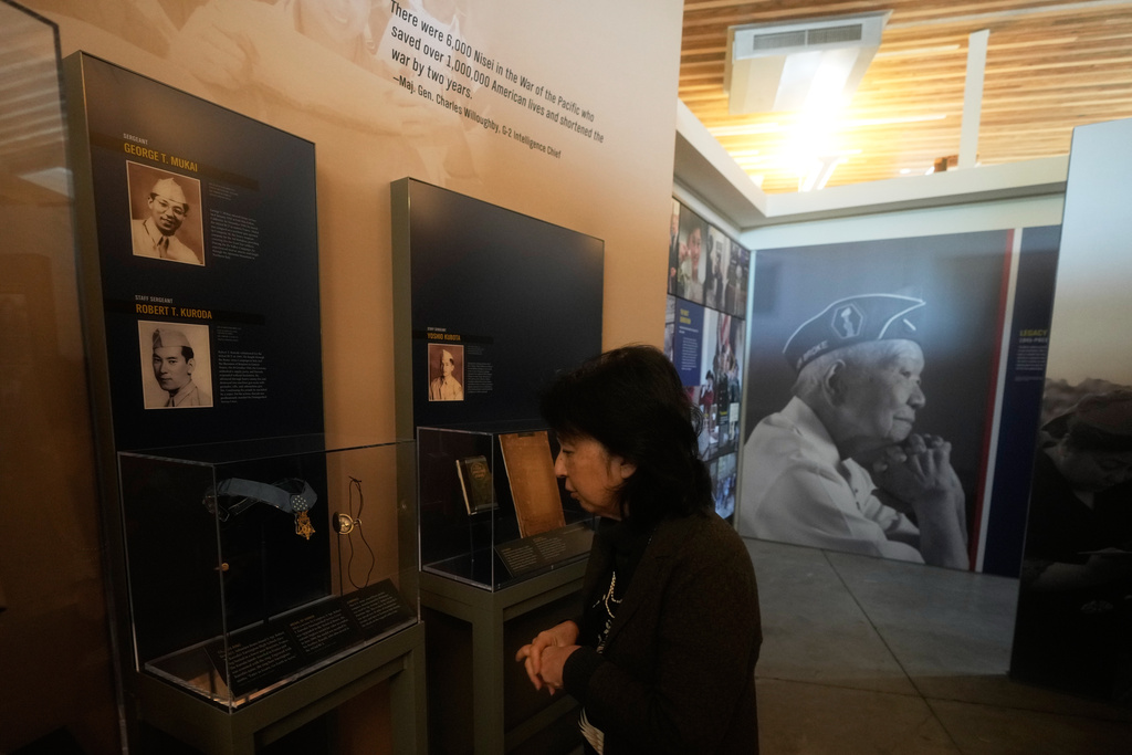 Rosalyn Tonai, Executive Director at the National Japanese American Historical Society, looks toward Staff Sgt. Robert Kuroda's class ring and Medal of Honor and Sgt. George Mukai's compass displayed in the "I am an American: The Nisei Soldier Experience" exhibit during an interview at the Military Intelligence Service Historic Learning Center in San Francisco, Wednesday, Feb. 25, 2026. (AP Photo/Jeff Chiu)