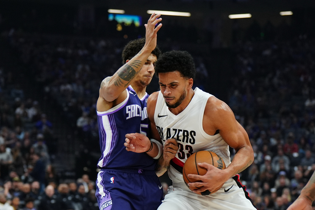 Portland Trail Blazers forward Toumani Camara (33) tries to drive past Sacramento Kings guard Nique Clifford (5) during the first half of an NBA basketball game Saturday, Dec. 20, 2025, in Sacramento, Calif. (AP Photo/Alan Greth)