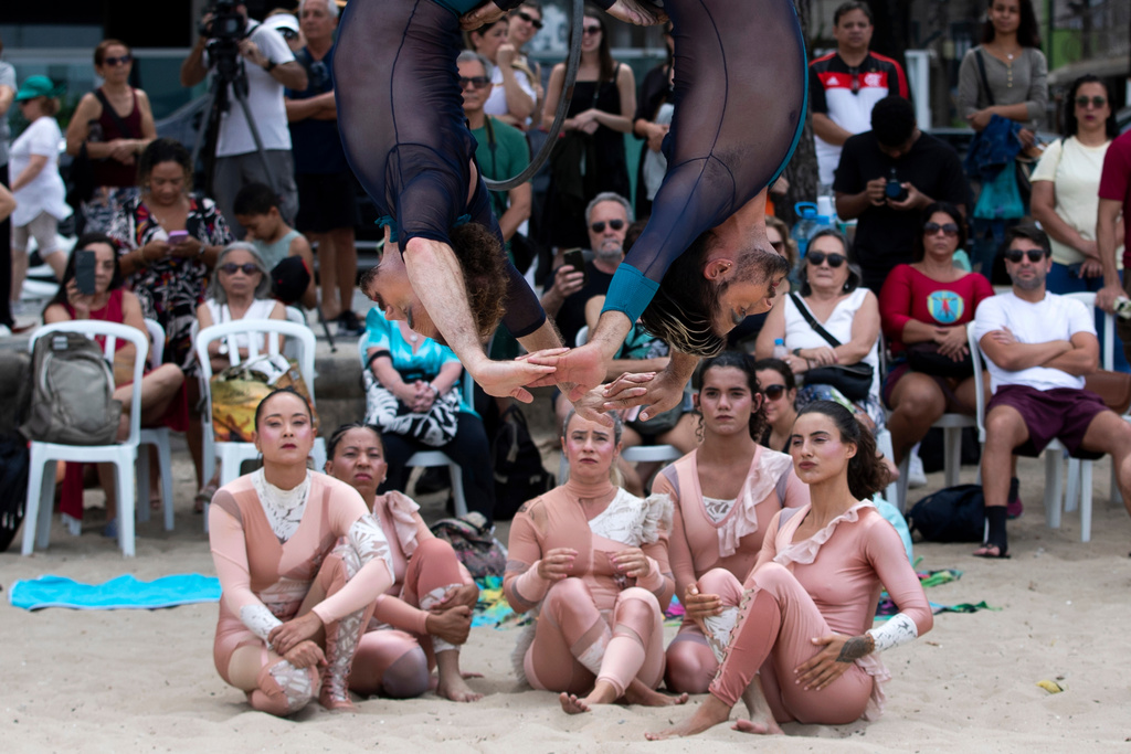 The aerial circus group "Pendurados” performs in an open-air show that explores healing from sexual violence through art and community, at Icarai Beach in Niteroi, Rio de Janeiro state, Brazil, Saturday, Oct. 18, 2025. (AP Photo/Bruna Prado)