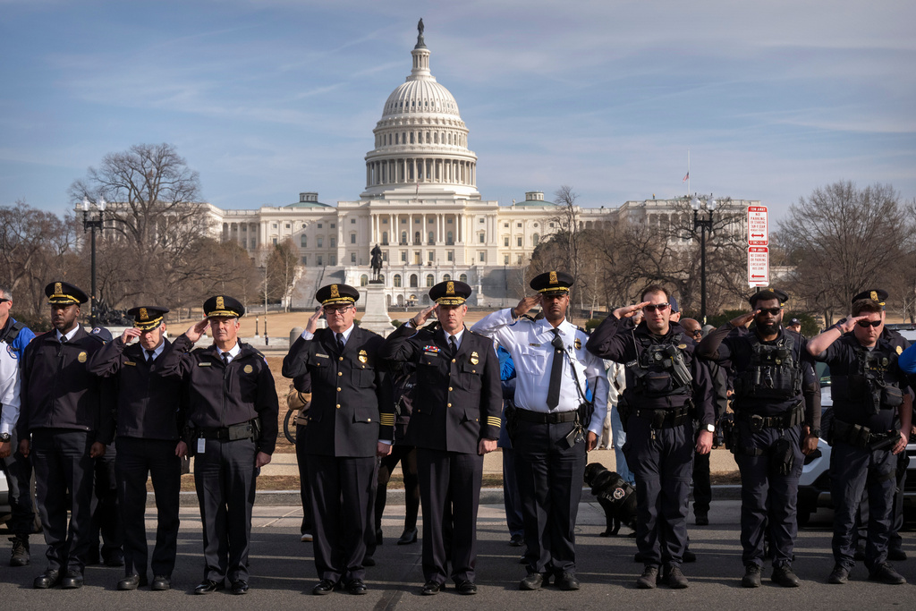 U.S. Capitol Police officers salute as a van carrying the body of Metropolitan Police Department officer Terry Bennett is driven past the Capitol, Thursday, Jan. 8, 2026, in Washington. (AP Photo/Mark Schiefelbein)