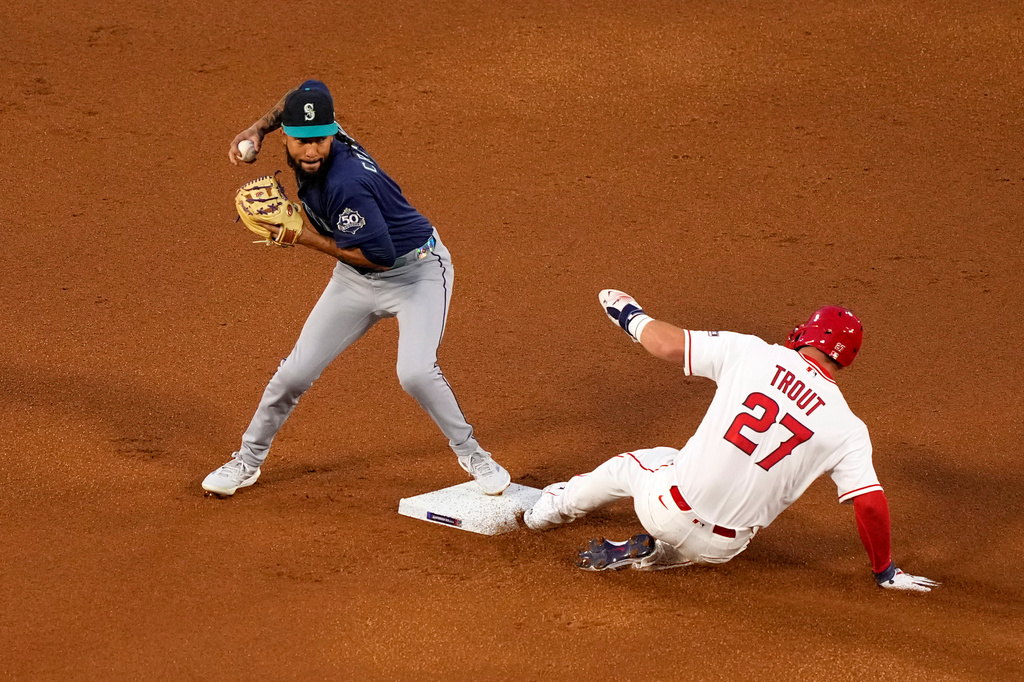 Los Angeles Angels' Mike Trout, right, is forced out at second by Seattle Mariners shortstop J.P. Crawford after Nolan Schanuel grounded into a fielder's choice during the first inning of an opening-day baseball game Friday, April 3, 2026, in Anaheim, Calif. (AP Photo/Mark J. Terrill)