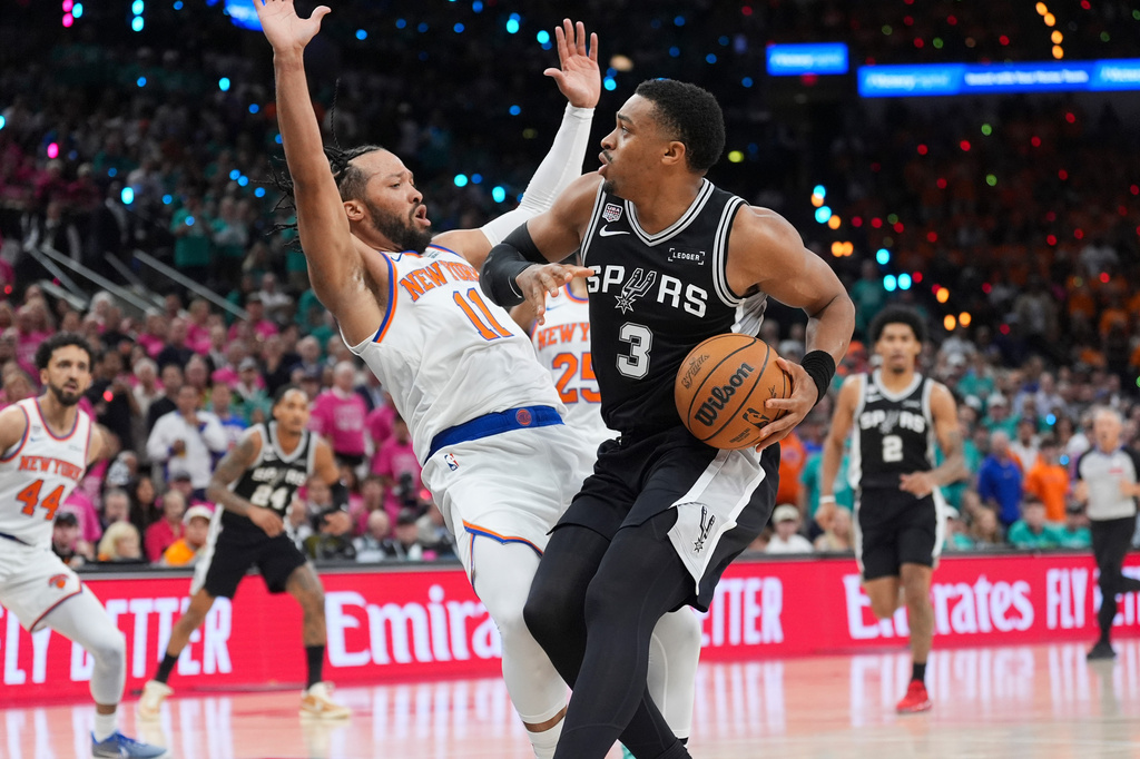 San Antonio Spurs forward Keldon Johnson (3) drives as New York Knicks guard Jalen Brunson (11) defends during the first half of Game 1 of the NBA Finals basketball series, Wednesday, June 3, 2026, in San Antonio. (AP Photo/Eric Gay)