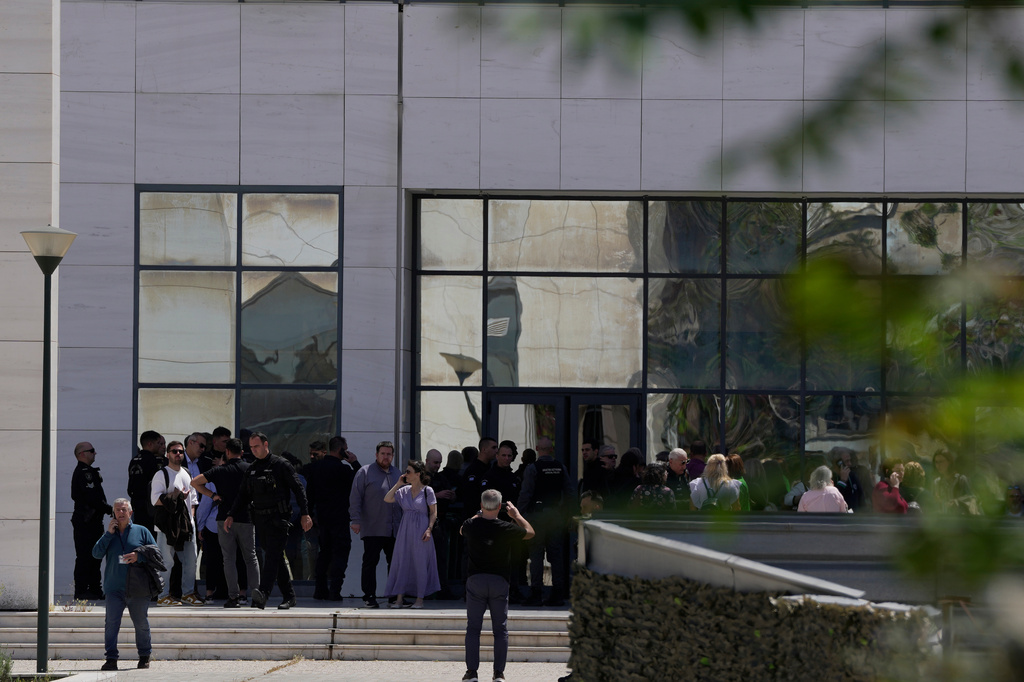 People gather outside a courthouse after a gunman opened leaving several people wounded in Athens, Tuesday, April 28, 2026. (AP Photo/Petros Giannakouris)
