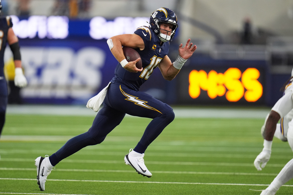 Los Angeles Chargers quarterback Justin Herbert (10) runs with the football during the first half of an NFL football game against the Minnesota Vikings Thursday, Oct. 23, 2025, in Inglewood, Calif. (AP Photo/Gregory Bull)
