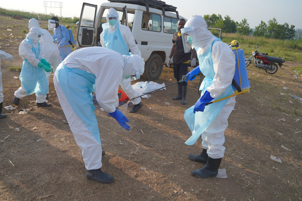 A health worker sprays a colleague with disinfectant after a burial service for Jacques Lobo Dhena, who died of Ebola in Bunia, Ituri province, eastern Congo, Wednesday, Aug. 12, 2026. (AP Photo/Dieudonne Dirole)