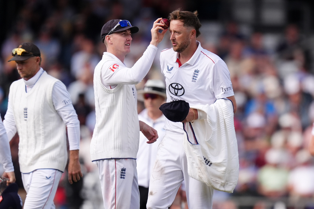 England's Harry Brook wipes the ball on the forehead of Ollie Robinson, right, on day one of the first Rothesay Test match between England and Pakistan in Leeds, England, Wednesday, Aug. 19, 2026. (Mike Egerton/PA via AP)